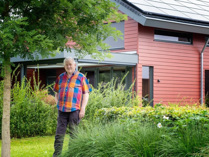 Inwoner Jos Lichtenberg staat in zijn tuin bij zijn huis