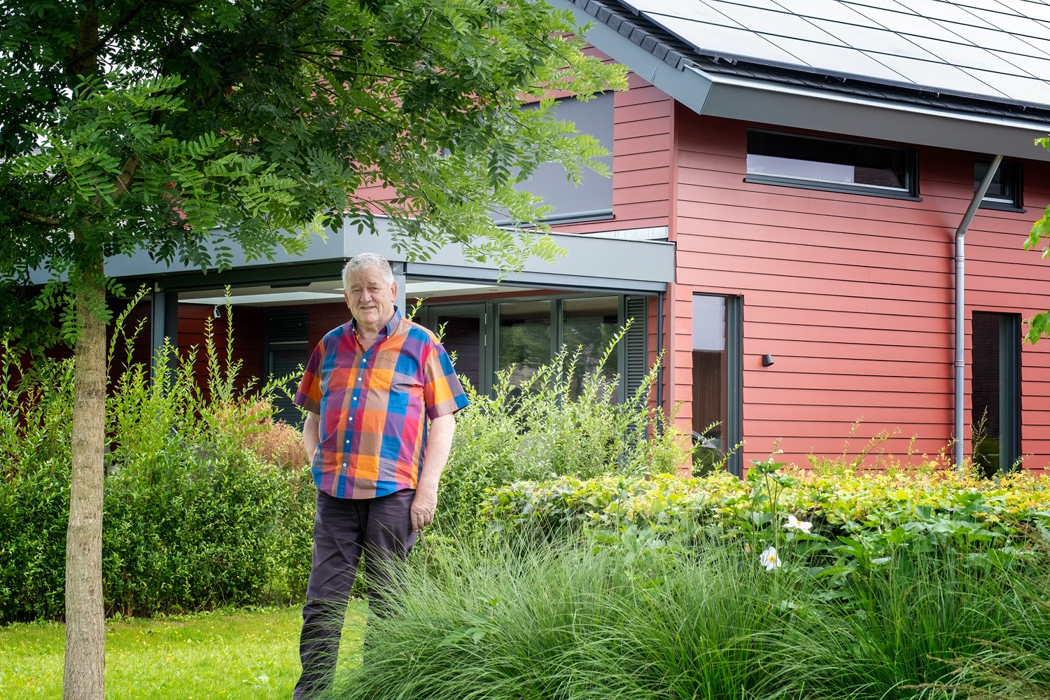 Inwoner Jos Lichtenberg staat in zijn tuin bij zijn huis